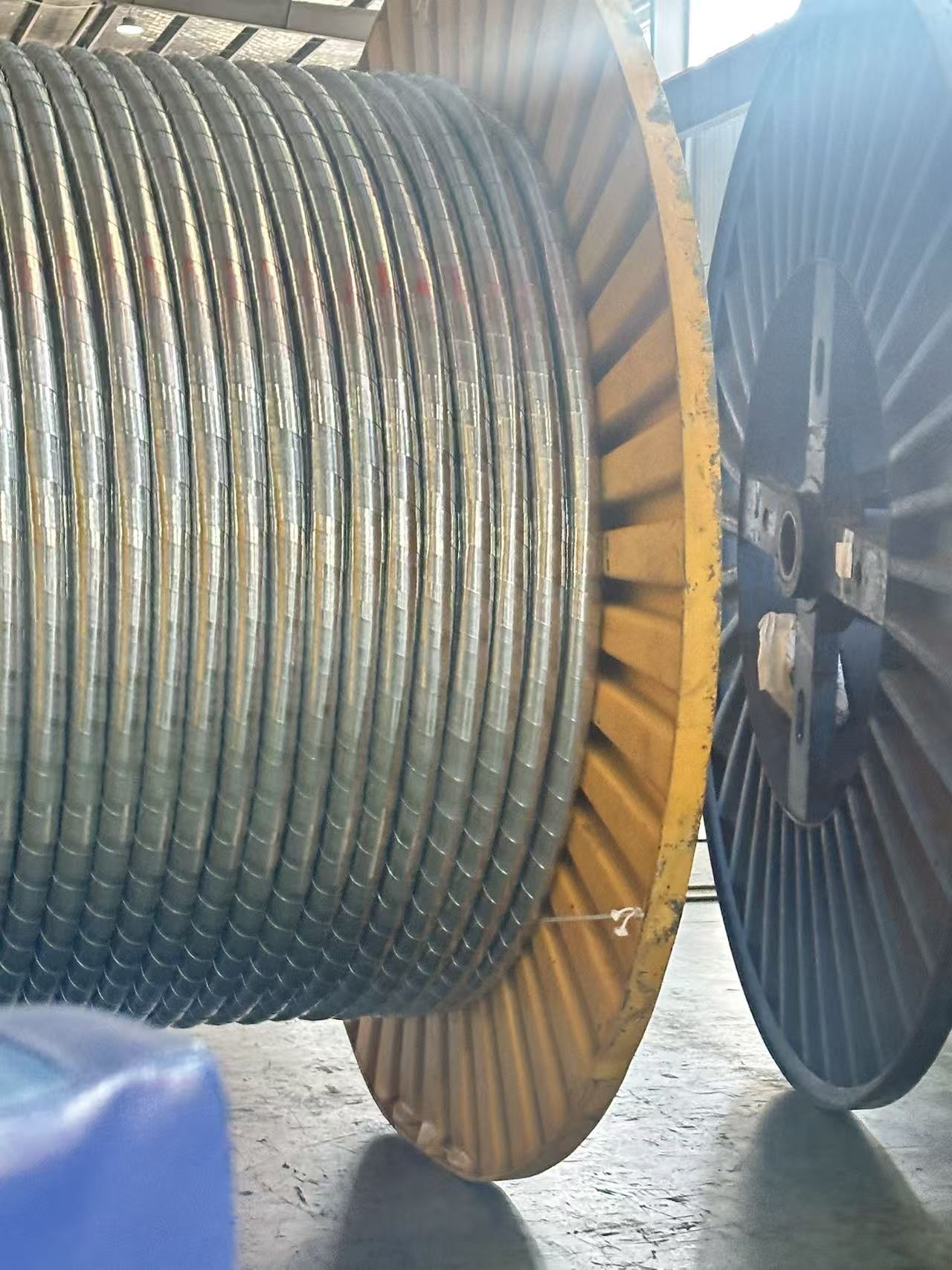 Close-up conductor reel inside a railway cable manufacturing facility